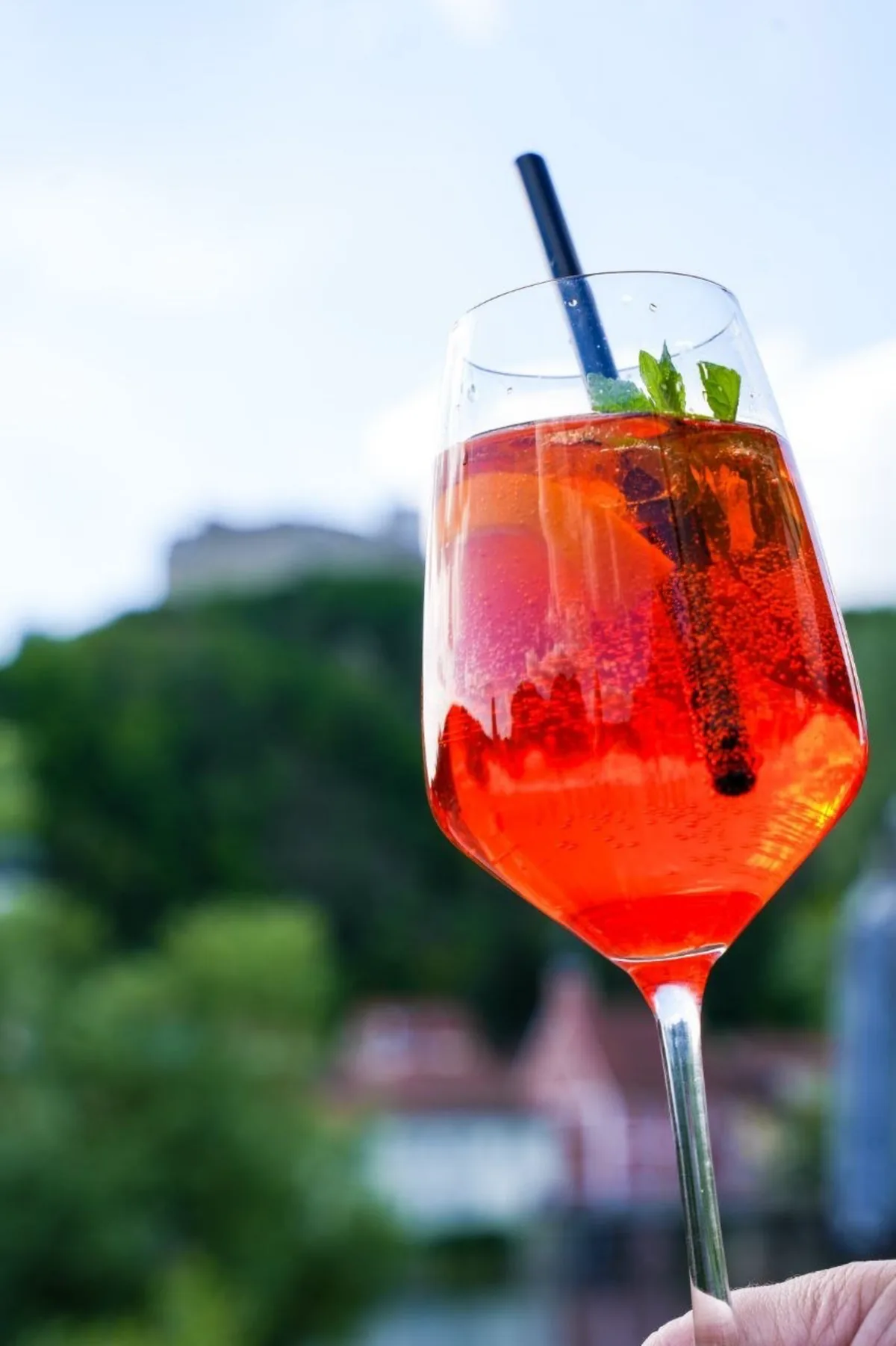 Aperol Spritz im Glas vor der Burgruine und dem Naabtal