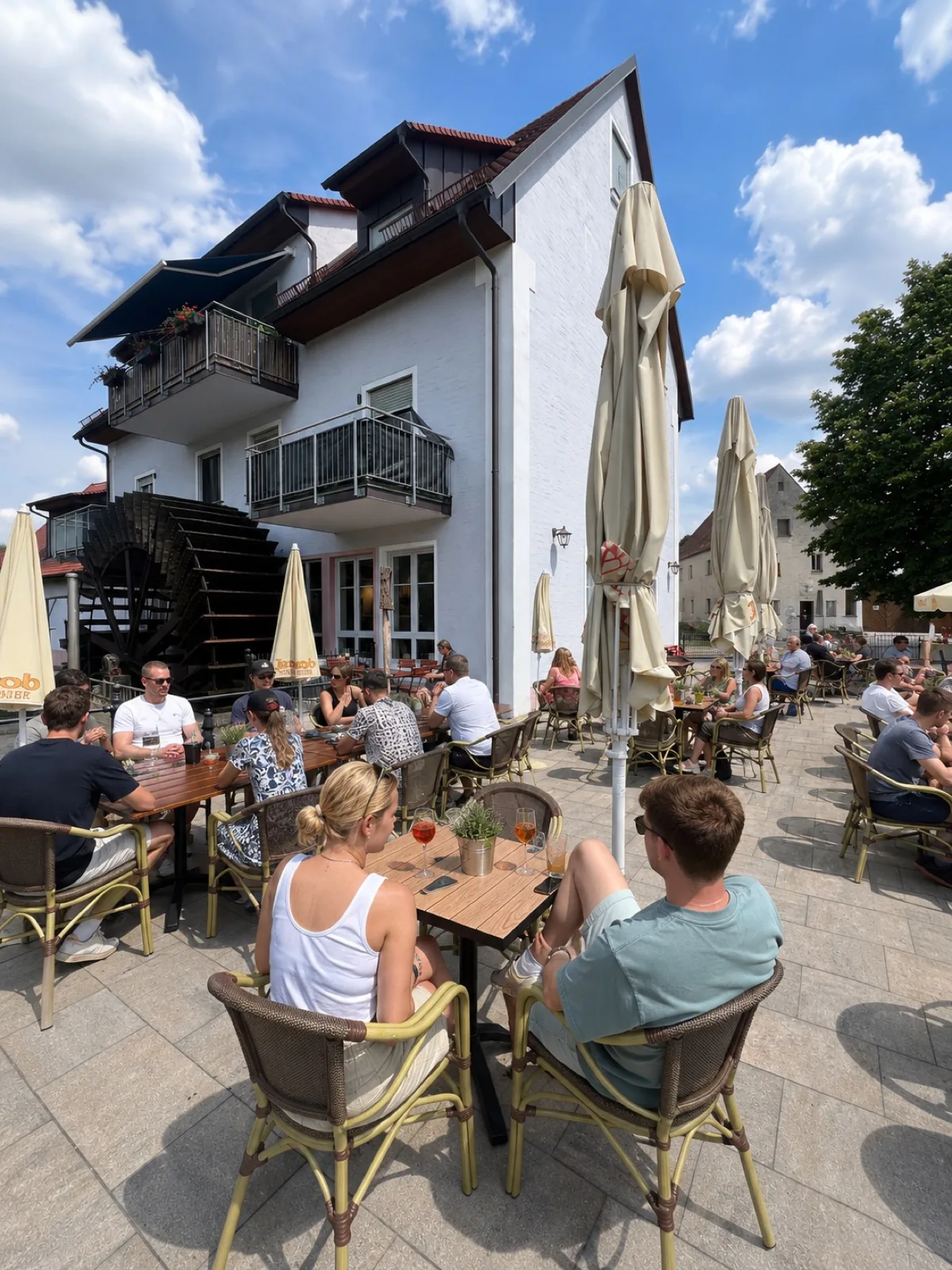 Gäste auf der Terrasse vor dem Mühlengebäude